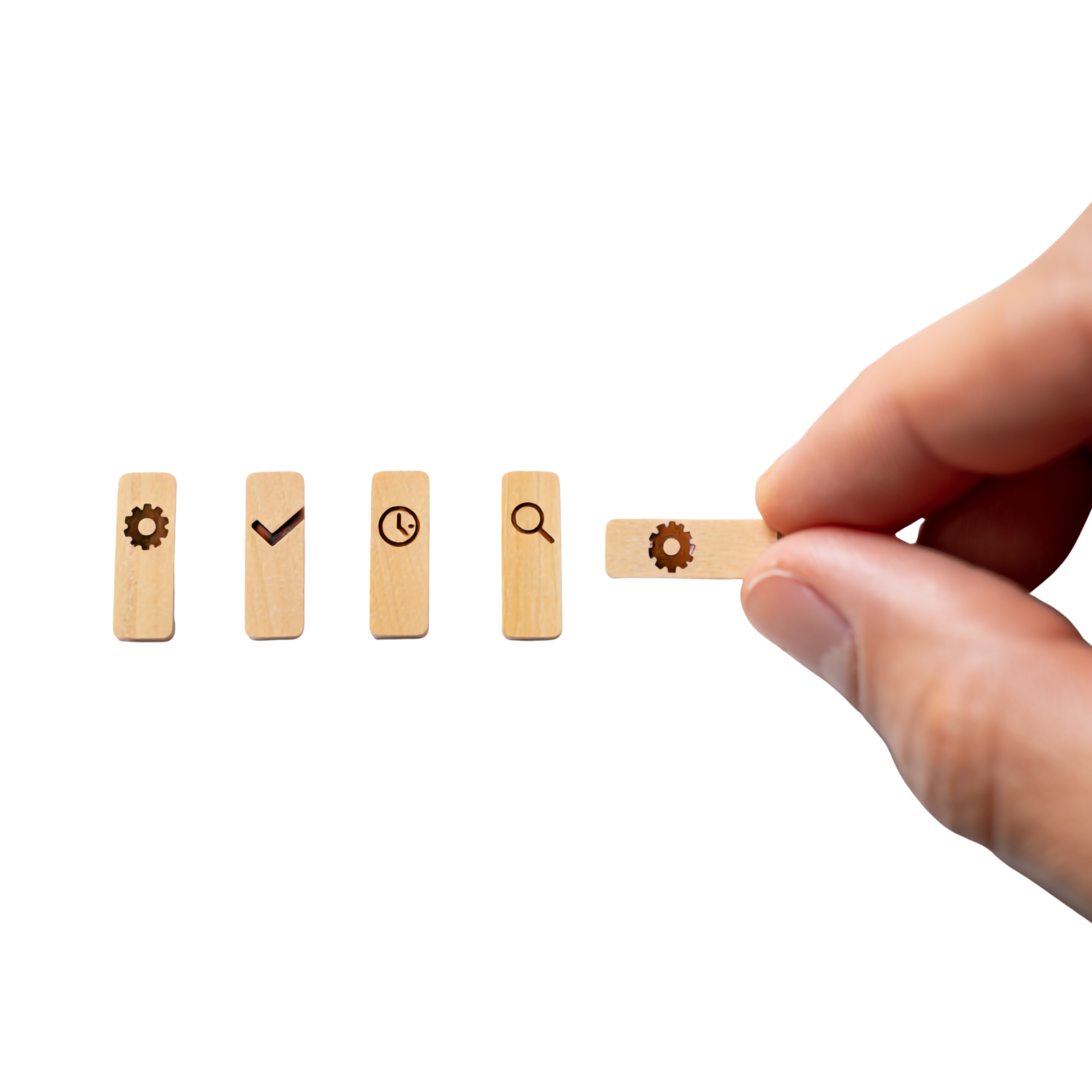 cztery drewniane prostokąty, na każdym symbol od lewej, zębatka,v, zegar i lupa, ostatni prostokąt jest trzymany między kciukiem i palcem wskazujący, jest na nim symbol zębatki