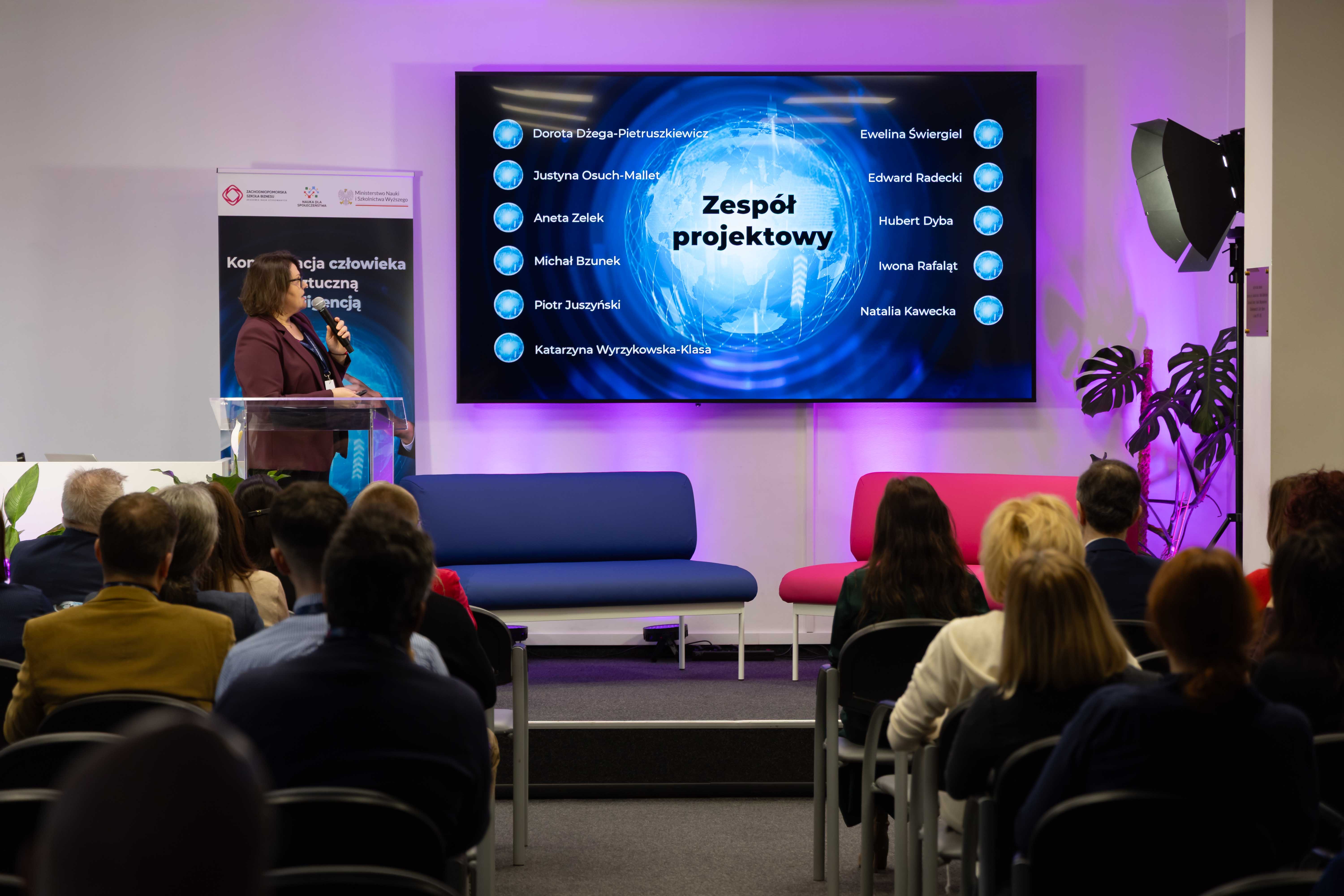 Sala konferencyjna, z widokiem na slajd przedstawiający zespół projektowy