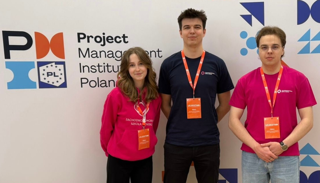 Trójka studentów w koszulkach uczelni ZPSB pozująca na tle ścianki reklamowej PMI