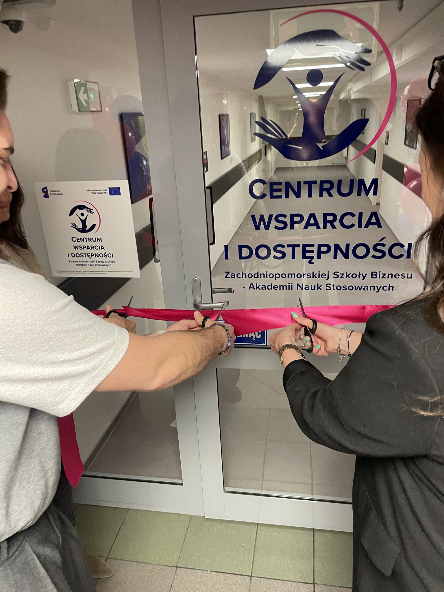 Dwie osoby przecinają wstęgę do wejścia strefy studenckiej
