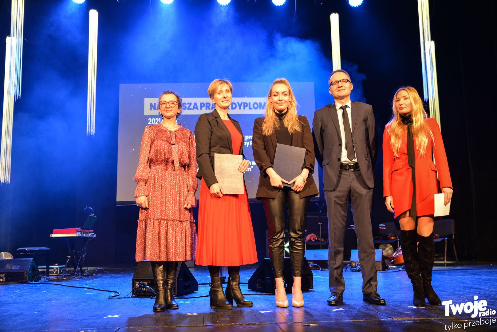 Na zdjęciu widocznych jest pięć osób: cztery kobiety i jeden mężczyzna. Dwie kobiety trzymają w ręku teczkę.